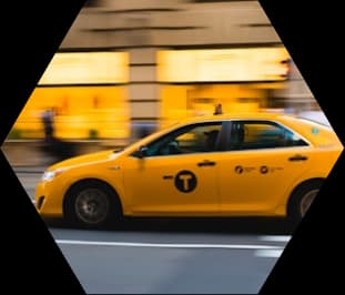 A yellow taxi moving through a city street
