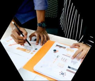 Hands reviewing printed charts and reports at a desk