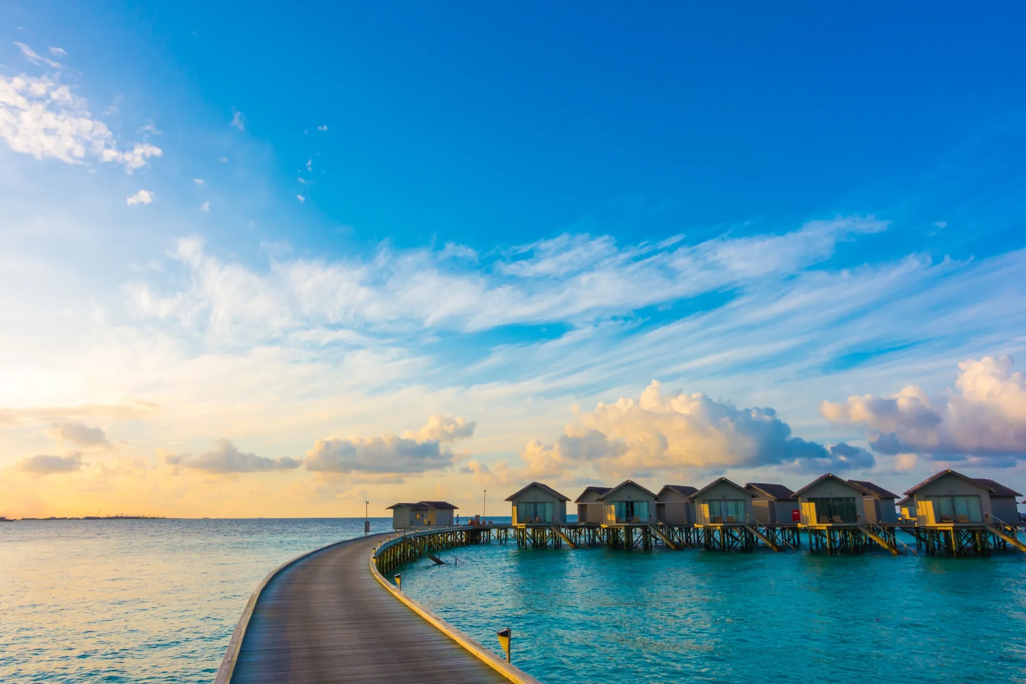Overwater bungalows on a tropical lagoon at sunset