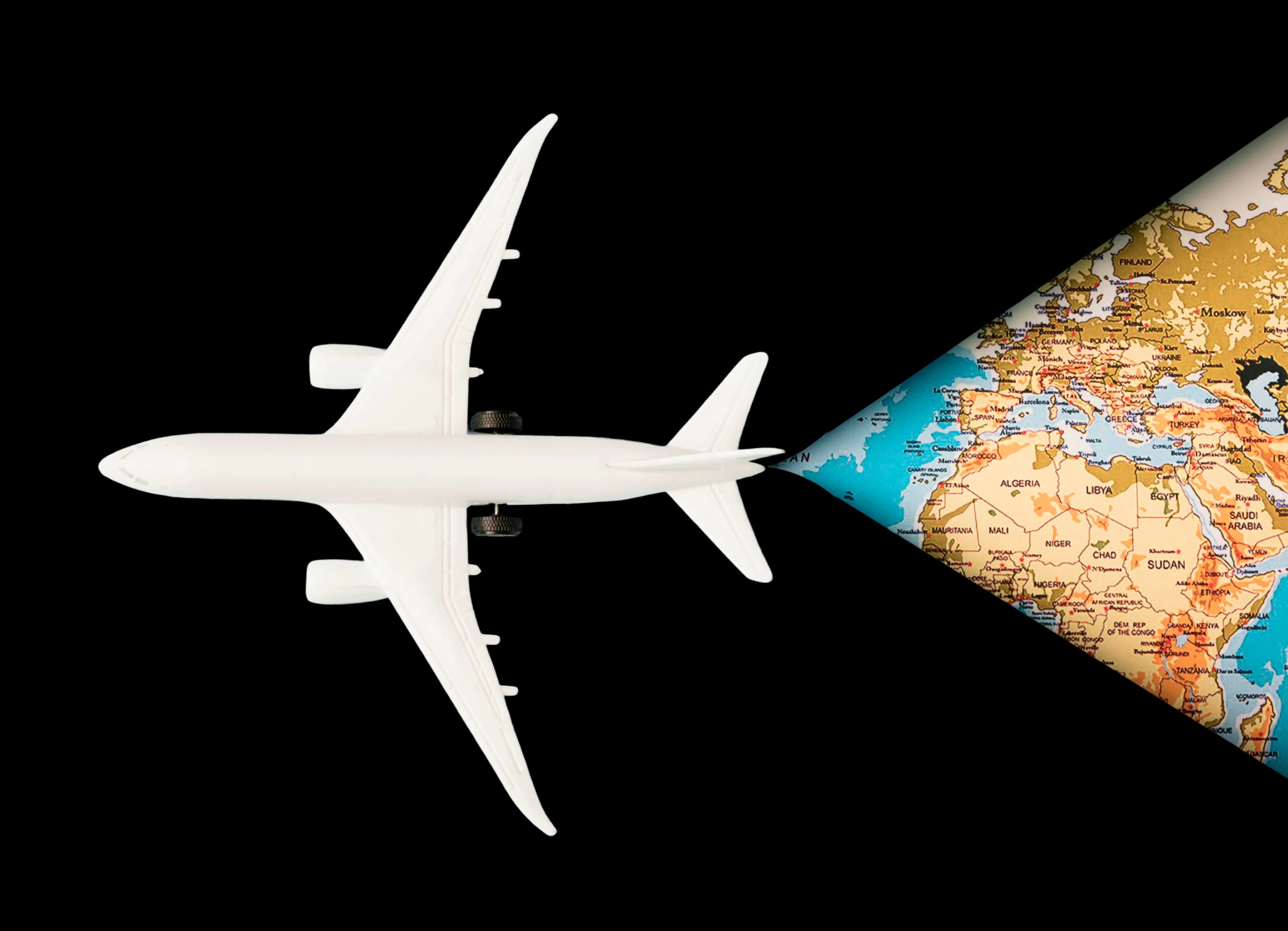 Top view of a white toy plane on a map
